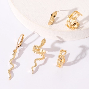 Makroaufnahme von Gold-Schlangen-Ohrringen mit Strass-Details und Schuppenstruktur