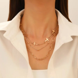 Three-layer gold-plated cross necklace with metallic beads shown on model