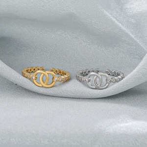 Detail of interlocking double band open rings with micro-set cubic zirconia in gold and silver