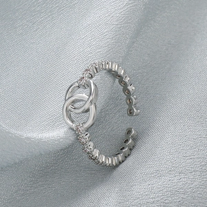 Detail view of silver open ring featuring a crystal-encrusted intertwined double-C motif