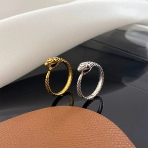 Close-up of vintage snake rings with scale textures and small black zircon eyes