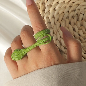 Close-up of bright green snake ring featuring intricate scale textures on a model's finger