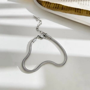 Detalle de una pulsera de cadena de serpiente plateada con cierre de mosquetón y cadena