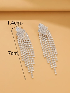 Detalle de pendientes de borla plateados con medidas 1,4 cm de ancho y 7 cm de largo