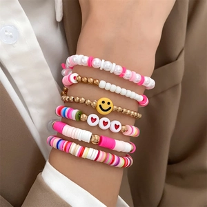 Detail of colorful clay bead bracelets with smiley face and heart on a model wrist