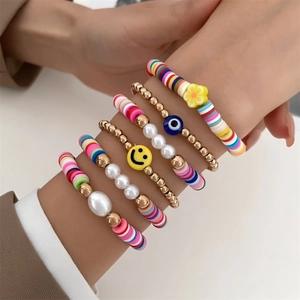 Detailed view of bohemian stacked bracelets featuring colorful clay beads and smiley charms