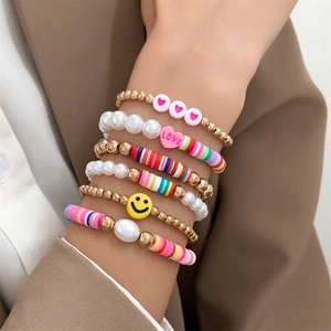 Detail of bohemian stretch bracelet set with smiley face, heart beads and colorful clay disks