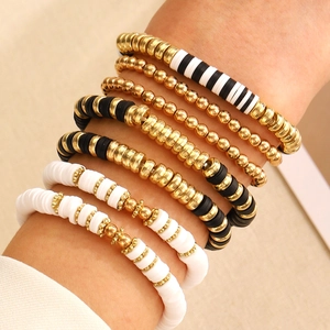 Detailed view of layered bohemian bracelet set with gold beads and clay Heishi discs