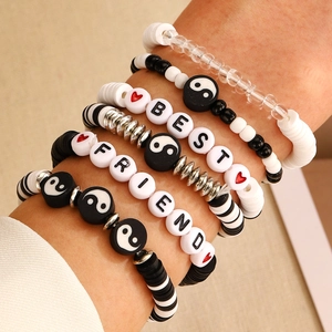 Detail view of colorful layered clay bracelets with BEST FRIEND letter beads and smileys