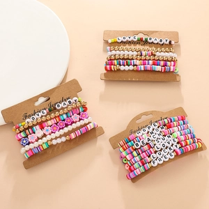 Close-up of vibrant clay bead bracelets with letter charms on a display card