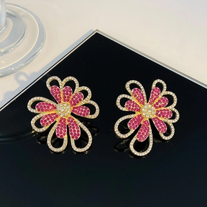 Pendientes de flores doradas con diamantes de imitación púrpuras y blancos en negro