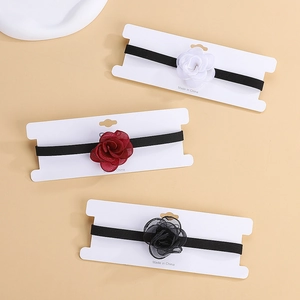 Detailed view of 3-piece floral baby headbands in red, white and black colors