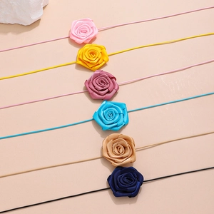 Detail of six colorful satin rose chokers including pink, blue, and yellow floral neckties