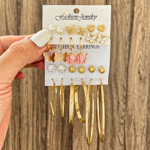 Vue détaillée d'un ensemble de boucles d'oreilles avec motifs papillon et perles