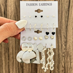 Détail macro de boucles d'oreilles en acétate avec perles et motifs acryliques sur cartes