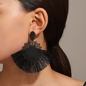 Primer plano de pendientes vintage de tela negra con borlas de estilo bohemio