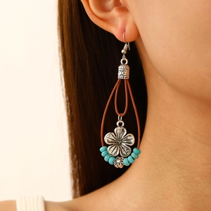 Detail of vintage bohemian dangle earrings with turquoise beads on female model