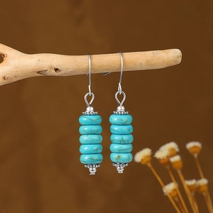Bohemian retro turquoise bead dangle earrings with vintage silver accents on wood branch