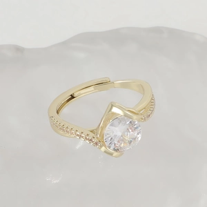 Close-up of golden four-claw ring with round center diamond and adjustable open band