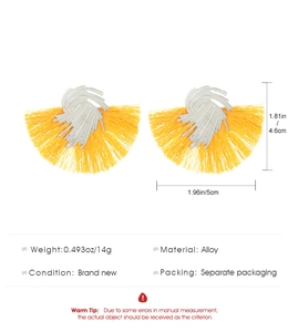 Detail view of yellow tassel earrings showing dimensions and alloy metal spiral design