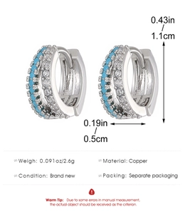 Detailed specs of copper hoop earrings with turquoise stones and clear zircon accents