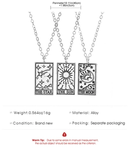 Macro detail of vintage tarot necklaces showing Sun, Moon, and Star pendant carvings