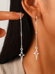 Close-up of gothic star drop earrings featuring linear dangle design and star charms