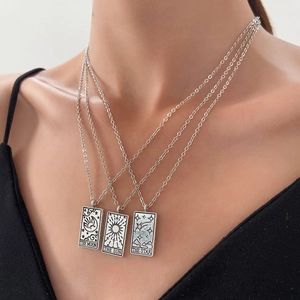 Detail of layered silver tarot necklaces with Moon, Sun and Star rectangular pendants