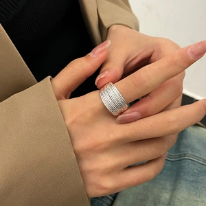 Detail of silver multi-layered stacked ring with textured bands on model hand