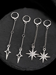 Macro detail of gothic star drop earrings with chains on a black stone plate