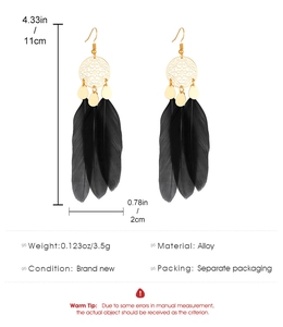 Detail view of long bohemian feather earrings with alloy discs and size measurements