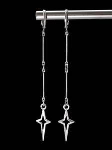 Close-up of silver long-drop star earrings with gothic punk style on black background