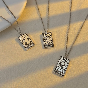 Macro detail of vintage tarot card pendants showing Star Moon and Sun motifs in silver