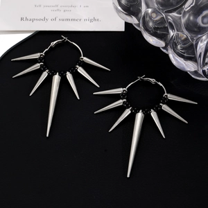 Punk style silver hoop earrings with metallic spikes and black beads on a dark base