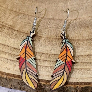 Detailed view of feather shaped wooden hook earrings with colorful ethnic patterns