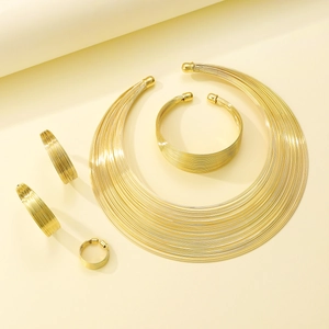 Detail view of five-piece gold multilayered metal jewelry set with sleek flowing lines