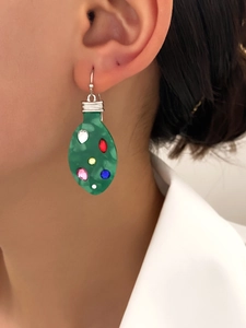 Close-up of green Christmas bulb drop earrings with colorful rhinestones on a model