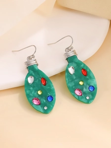 Detail shot of green resin Christmas bulb earrings with colorful rhinestones on white base