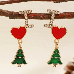 Detail of Christmas tree earrings with red heart and rhinestones on a rustic branch