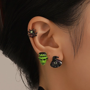 Detail of Halloween earrings set featuring black spider, green monster and wizard hat