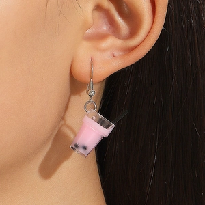 Detailed close-up of a creative mini pink bubble tea earring worn by a model