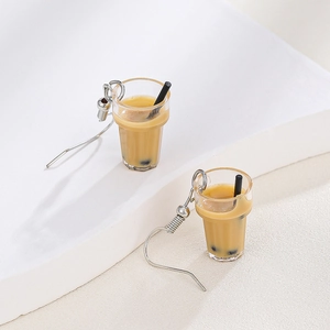 Macro detail of creative pearl milk tea earrings with resin texture and silver hooks