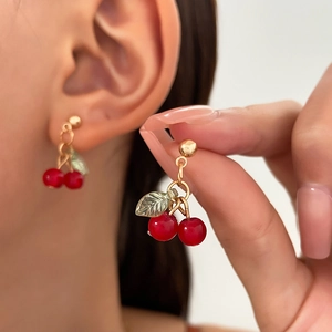 Elegant cherry pendant earrings with red resin beads and green metal leaves in gold finish