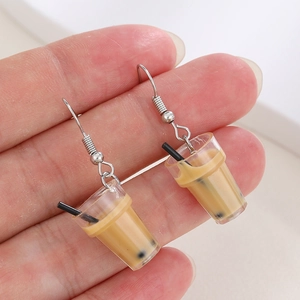 Close-up of miniature bubble tea cup earrings held in hand to show creative details