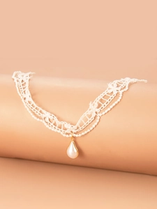 Detailed view of cream lace choker featuring a teardrop pearl pendant with gold trim