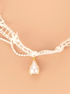 Detail view of white lace choker necklace with a gold-edged faux pearl droplet pendant