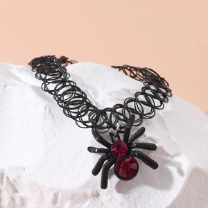 Gothic black elastic tattoo choker with a red rhinestone spider pendant on white stone