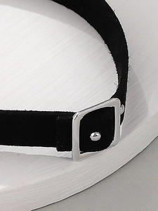 Macro view of black velvet choker featuring a silver square buckle and bead detail