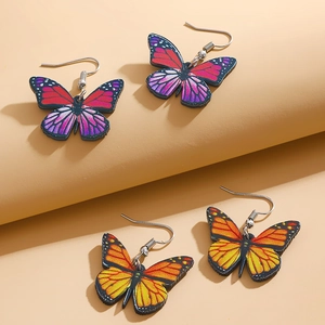 Detailed close-up of acrylic butterfly drop earrings with colorful gradient wing patterns