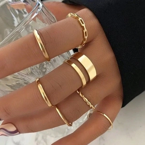 7-piece minimalist golden knuckle ring set with chain and smooth bands on a model